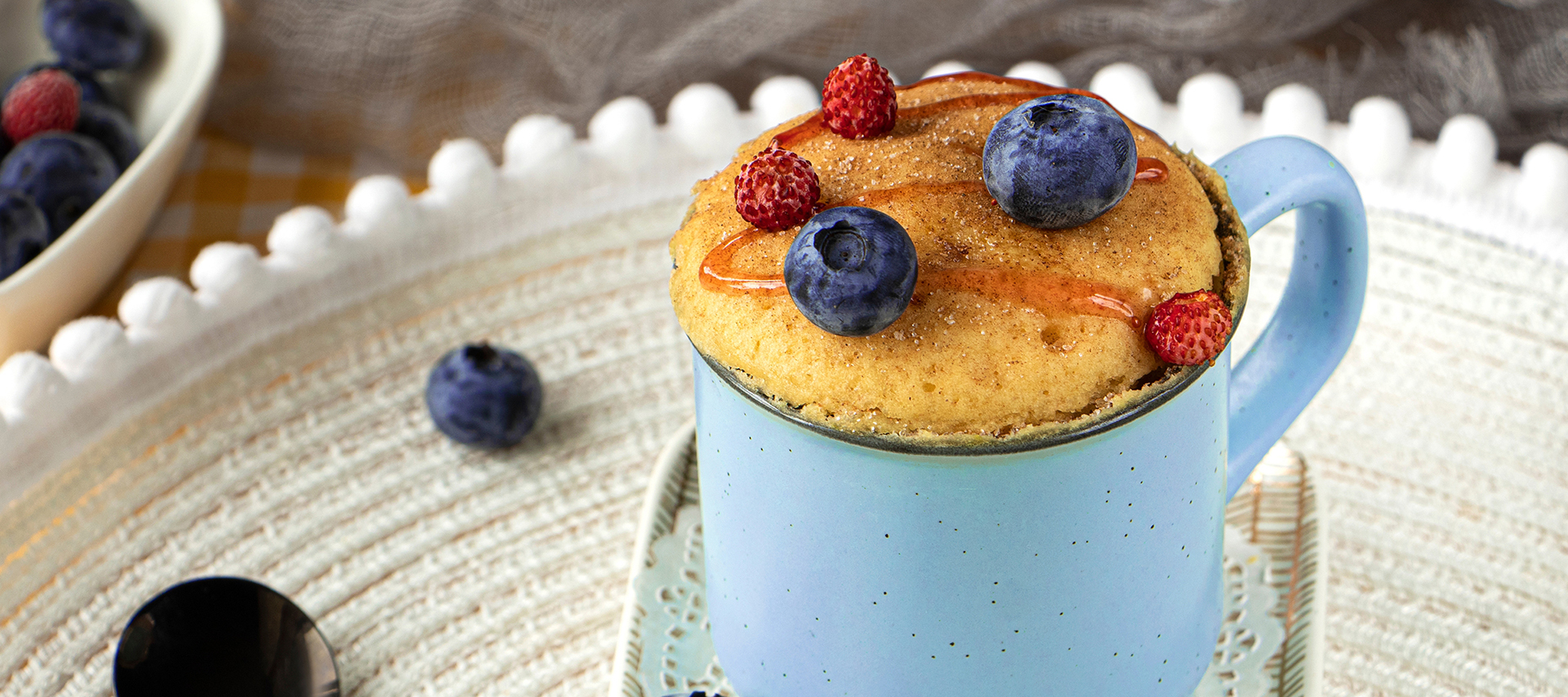 Delicious homemade blueberry muffin mug cake with fresh berries. Cooked in a mug in the microwave.